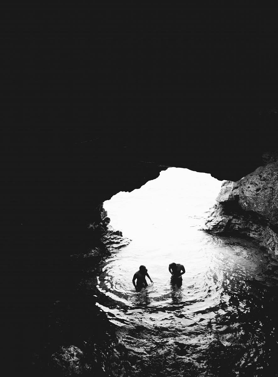 iphone wallpapers grayscale photo of two men in cave with body of water iphone backgrounds